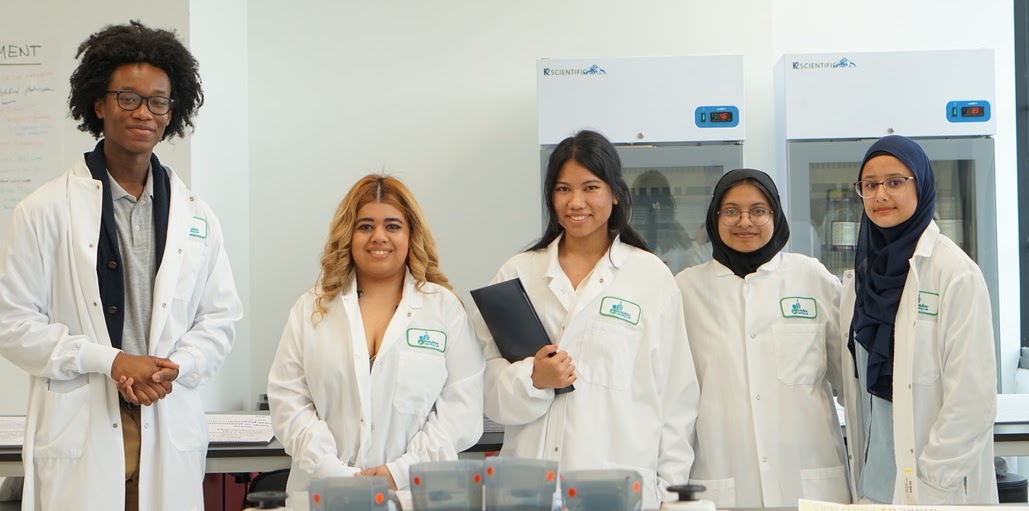 Two people smiling in lab coats