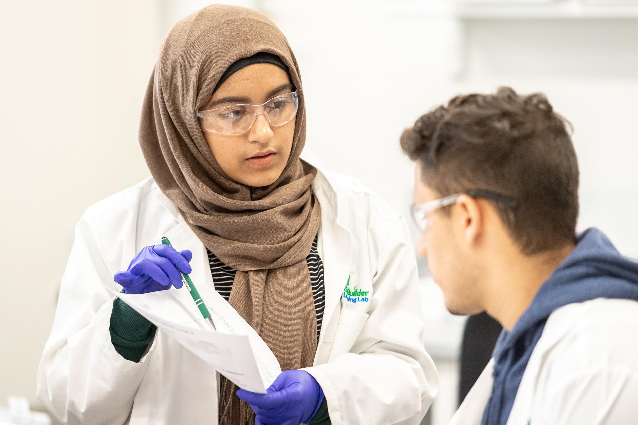 Two people smiling in lab coats