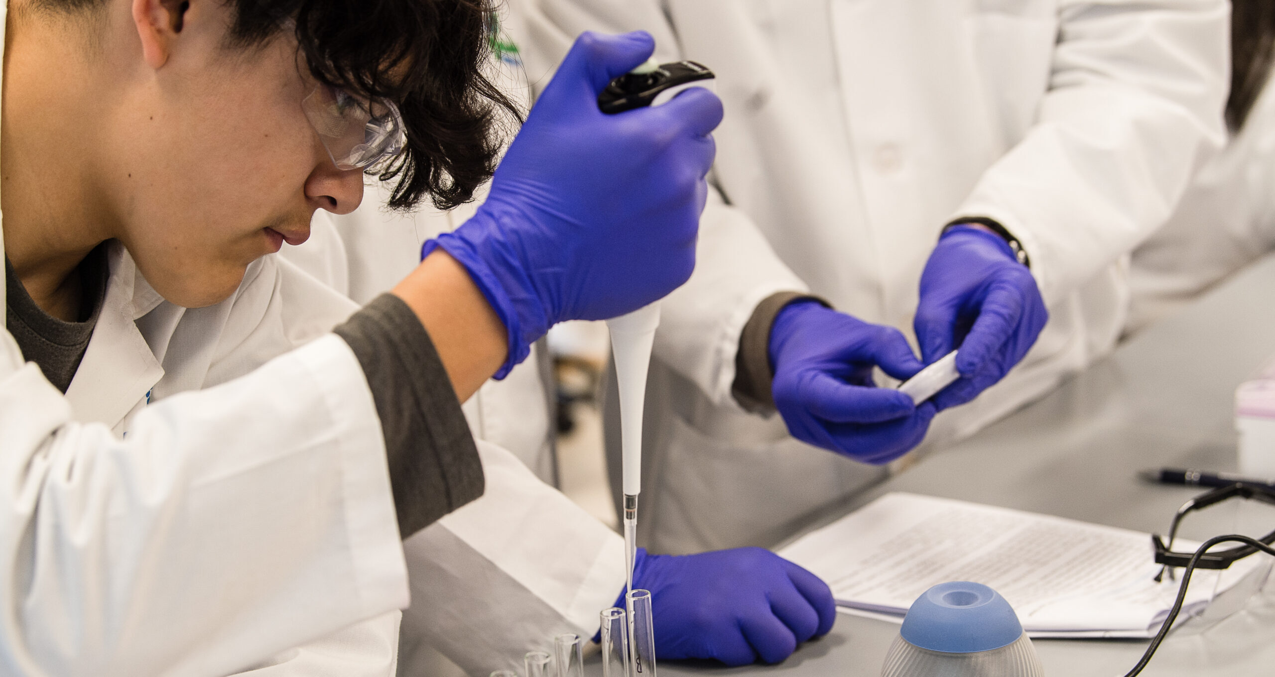 Two people smiling in lab coats