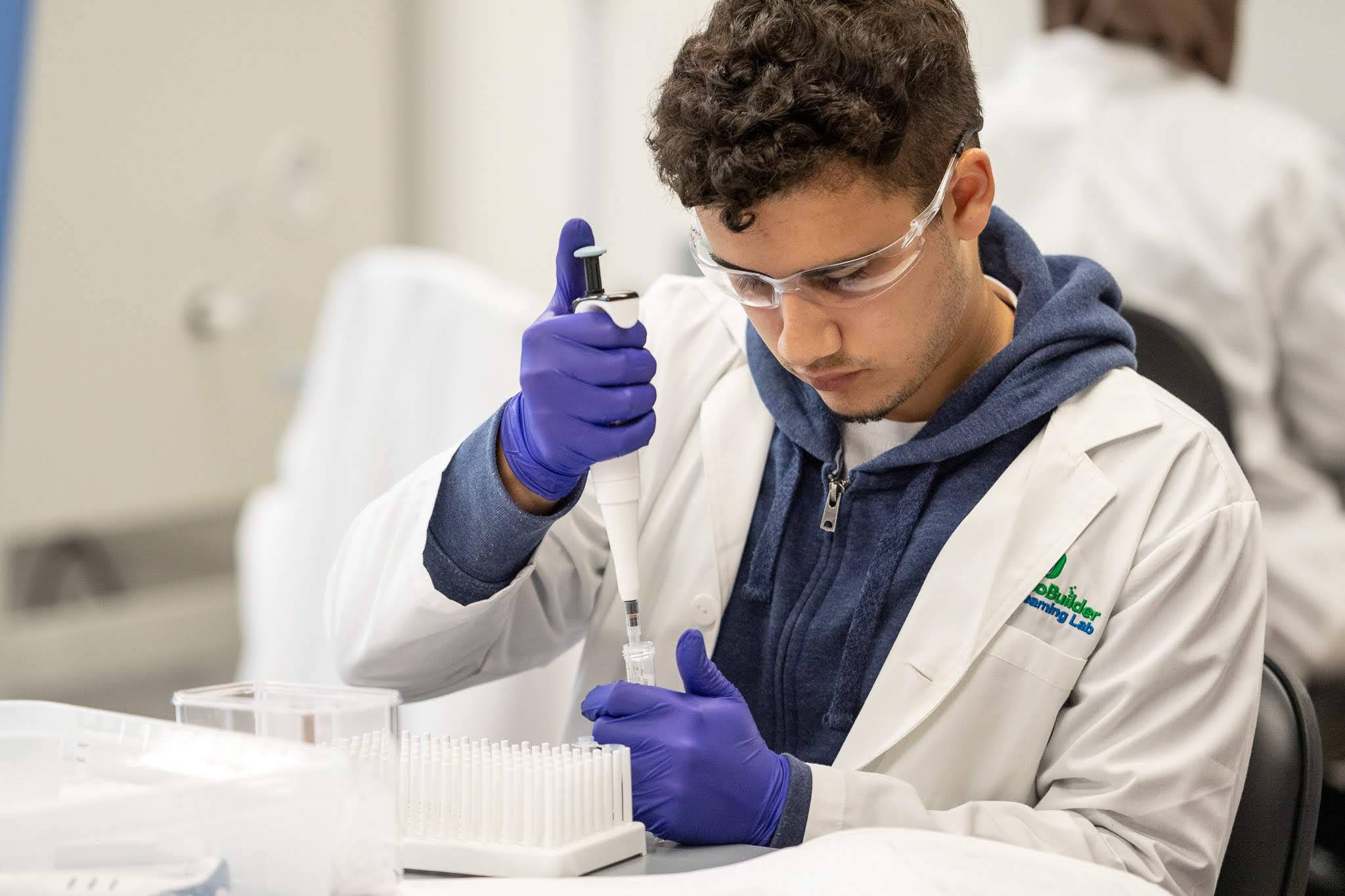 Two people smiling in lab coats