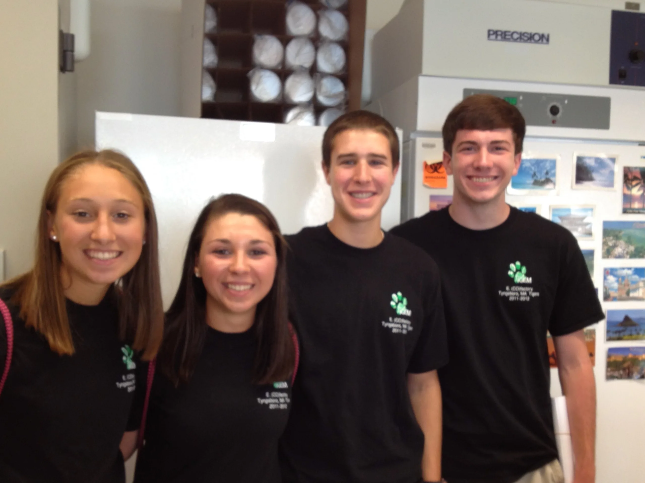 Four people standing in front of their scientific poster