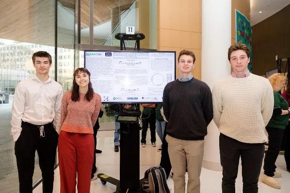Four people standing in front of their scientific poster
