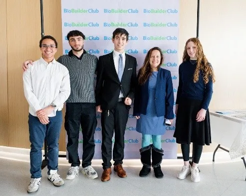 Four people standing in front of their scientific poster