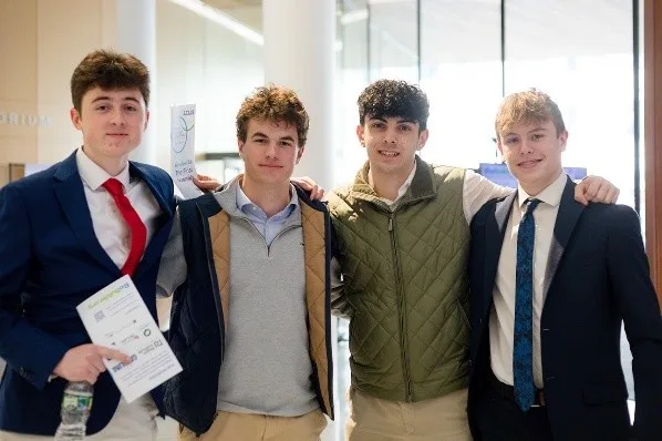 Four people standing in front of their scientific poster