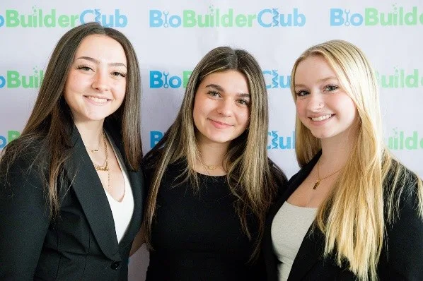 Four people standing in front of their scientific poster