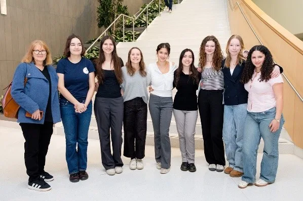 Four people standing in front of their scientific poster