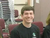 Five students wearing matching t-shirts smiling