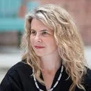 Photo of Karen Ingram, a light skinned person with long blonde hair, wearing a black shirt and necklace